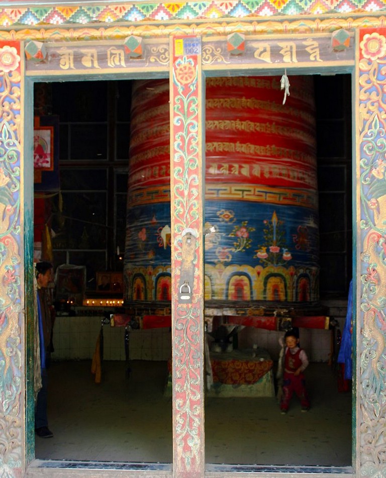 Prayer wheel and pilgrims at the The Original Yushu Seng-ze Gyanak Mani Wall before the 2009 Earthquake